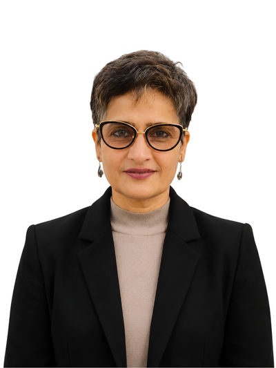 A woman with short dark hair wearing black cat-eye eyeglasses, a black blazer, and a beige turtleneck sweater, photographed against a plain white background.